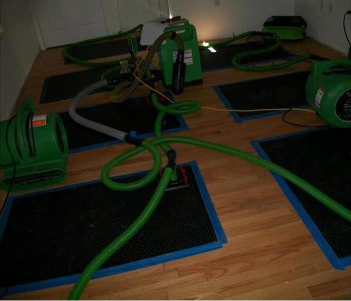 six drying mats and equipment on a hardwood floor