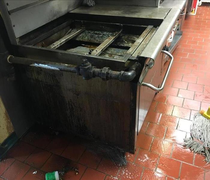 greasy tile floor in commercial kitchen, greasy oven and gas line